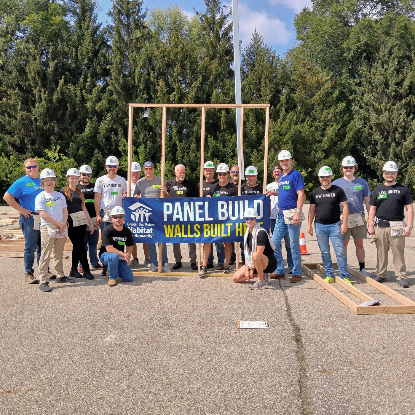 The Willis Automotive team at a Habitat for Humanity Panel Build day, posing with a freshly framed wall and a Greater Des Moines Habitat for Humanity banner.